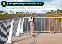 a woman is standing on a railing next to a river