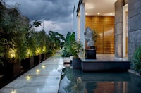 the entrance to a modern home has a water feature