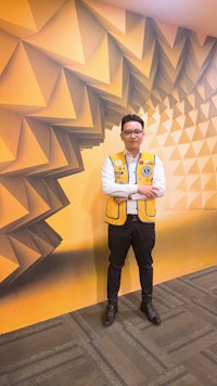 a boy scout standing in front of a yellow wall