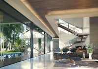 a modern living room with glass walls and a staircase